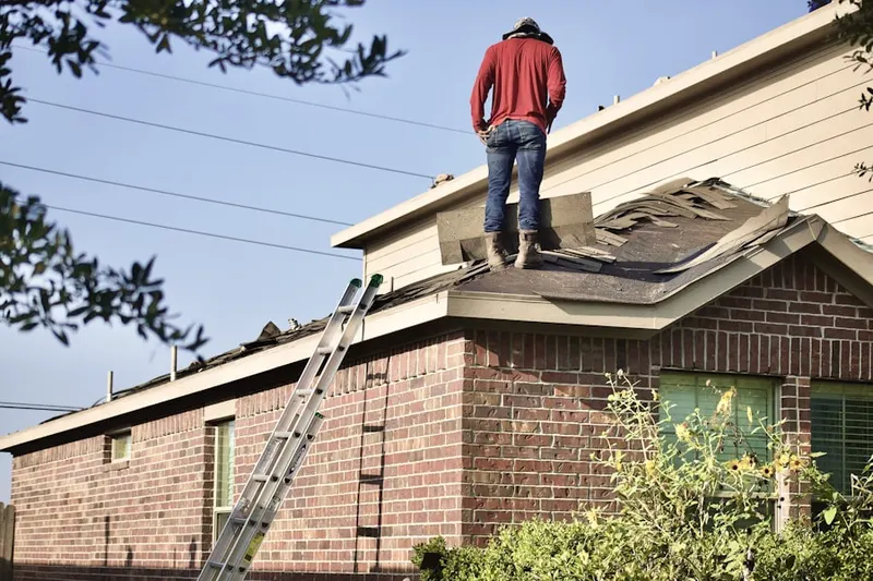 Professional roofer working on a residential roof in West Des Moines
